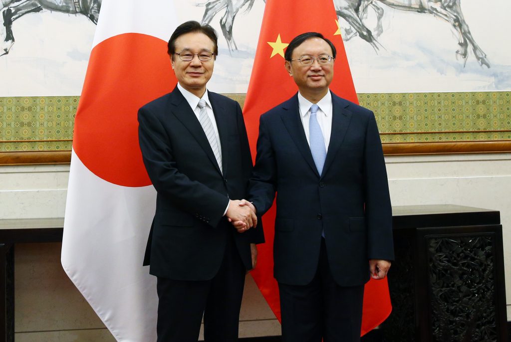 Japanese National Security Council chief Shotaro Yachi (L) shakes hands with Chinese State Councilor Yang Jiechi ahead of a meeting at the Diaoyutai State Guesthouse in Beijing on Aug. 25. WU HONG/AFP/Getty Images